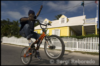 Nen amb bicicleta i típica casa lealista. Bay St Dunmore Town - Harbour Island-Eleuthera. Bahames