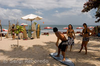 Platja de Kuta. Mentre uns turistes pratica surf altres reben classes a la sorra. Bali.