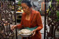 Una dona es dirigeix a l'interior d'un temple per resar i deixar les seves ofrenes durant la celebració del Galungan. El festival de Galungan, el més important de Bali, simbolitza la victòria de Drama (virtut) sobre Adharma (mal). Durant els dies que duren les celebracions dels balineses desfilen per tota l'illa adornada amb pals llargs de bambú (penjor) decorat amb panotxes de blat de moro, coco, coques i pastissets d'arròs així com teles blanques o grogues, fruites flors. Aquesta festa se celebra cada 210 dies. Ubud. Bali.