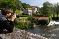 Un turista realitza fotografies des del Ponte Maceira hacia el Río Tambre.