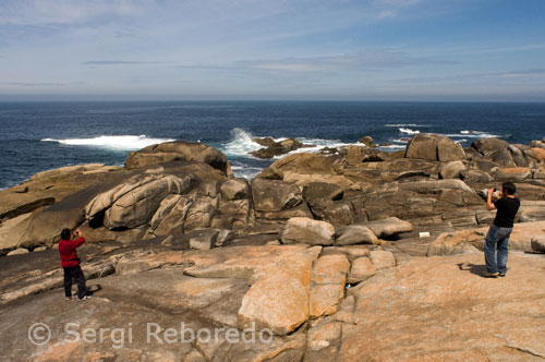 Turistes fotografiant la "Pedra do Timón ', per la seva semblança amb el timó d'un vaixell i també es relaciona amb la llegenda de la Verge.