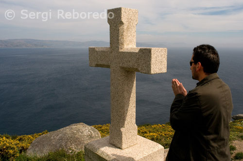 Pregar en un cruceiro a la part posterior del far de Fisterra.