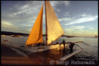 Els visitants de l'illa lloguen aquestes embarcacions per veure la posta de sol des del mar. Barca per la pràctica del sailing. White beach. Boracay.