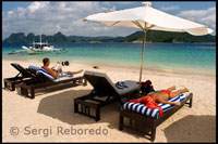 Hotels de luxe i platges solitàries en illes remotes de Filipines. Turistes descansant a les hamaques de l'illa de Pangulasian. Palawan.