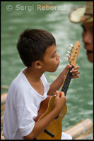 Un nen canta al marge del riu Loboc a l'arribada dels turistes mentre aquests realitzen un trajecte en barca. Loboc. Bohol.
