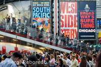 Times Square constitueix una part de Manhattan dissenyat amb la més alta tecnologia lluminosa dels últims dies els enormes anuncis animats li donen a la Gran Poma un ambient impactant mai vist en altres països del món, pel que fa a recreació es refereix. Els gegantins edificis són coberts en les seves primeres plantes per enormes avisos publicitaris com Toyota, Toys for Us, Quick Silver, Línies aèries, McDonald's, reconegudes i populars companyies de roba, Bancs, i altres molt familiars per a molts, .. El soroll es torna comú, acceptable i familiar, i és una barreja d'expressions de la gent, de rizas, de sorpreses, de les ambulàncies, el caminar dels cavalls que tiren els carruatges, les actuacions policials, els músics de carrer, .. La gent multiètnica entra i surt dels magatzems amb el vostre llengua d'origen, per continuar el seu passeig inoblidable pels carrers celestials de Times Square, mentre els caricaturistes asiàtics es guanyen de 5 a 10 dòlars cada 5 o 10 minuts. La seva habilitat per a aquest negoci s'aglomera a molta gent al seu voltant que esperen veure acabada la seva obra d'art i somriure per la gràcia dels seus remarcades característiques facials distorsionades. Una olor que canvia mentre es camina, provocat pel venedor de "Hot dogs", "Pretzels", piques, maní i coco encaramel · lats, xocolates, que no descansen un moment, somrient atenen als seus clients que esperen el seu torn mirant admirats a la seva voltant.