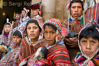 La gent de la muntanya vestida amb vestits tradicionals a la porta de l'església de Pisac el diumenge, dia de mercat. Pisac. Valle Sagrado.