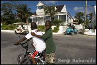 Niños en bicicleta y casa lealista. Bay St. Dunmore Town - Harbour Island -Eleuthera.