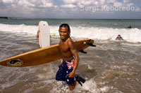 Un surfista con su tabla en la playa de Kuta. Bali.