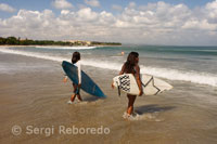 Dos mujeres surfistas con sus tablas en la playa de Kuta. Bali.
