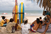 Playa de Kuta. Mientras unos turistas deciden practicar surf otros descansan en la arena. Bali.