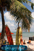 Playa de Kuta. Mientras unos turistas deciden practicar surf otros descansan en la arena. Bali.