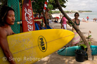 Playa de Kuta. Mientras unos turistas deciden practicar surf otros descansan en la arena. Bali.