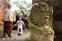Varias personas junto a una estatua hinduista de piedra en la puerta del Templo Pura Gunung Lebah. Ubud. Bali. 