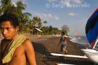 Unos pescadores llevan hasta la orilla sus barcas cerca de la playa de Amed, un pueblecito pescador del Este de Bali. 