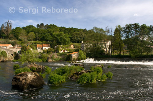 Casas en el río Tambre que pasa a través de Ponte Maceira.