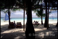 Paisaje con palmeras. Bankas en White beach. Embarcadero de Boracay.