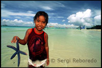 Niña con una estrella de mar.  White beach. Boracay.