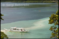 Vista desde una montaña cercana de Snake Island, que toma el nombre por su forma de serpiente cuando baja la marea. Palawan. La barca está esperando a los turistas en esa especie de serpiente arenosa. 