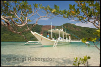 Una barca atracada en la arena blanca de la isla de Snake. Palawan cuando la marea está baja.