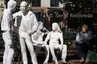 Estatuas blancas en la plaza de Christopher Park en el barrio de Greenwich Village. Sheridan Square con Christopher St. La parada de metro del mismo nombre Christopher St - Sheridan Sq <M> 1-2-3-9 nos deja en esta plaza. Nada más salir del metro si nos fijamos en la esquina de la séptima con Christopher, la tienda de cigarrillos “Village Cigars” destaca sobre el resto del paisaje por la gran cantidad de publicidad que se apelotona a su alrededor. Justo cruzando la calle llegamos a Christopher Park, un parque triangular con varias estatuas blancas del mismo tamaño que las personas que pasean por él. En el extremo de la plaza y escondida entre los árboles se levanta una figura de bronce en honor al general Philip Sheridan que participó en la guerra de Secesión. En esta plaza también se encuentra el que fuera famoso bar Stonewall Inn que el año 1969 fue un resorte para el movimiento gay y sus luchas contra la discriminación a la que eran sometidos.