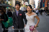 Un par de asiáticos recién casados celebran su luna de miel en la zona de Times Square. En el centro de esta espectacular combinación de luces, movimiento, vida y colores, se abrió este año, un espacio amplio para que los turistas descansaran o miraran a su alrededor la impresionante exhibición de arte desarrollado por publicitas que en su conjunto, le dan a Times Square el calificativo del Centro de la Gran Manzana y del Mundo, la Ciudad que nunca duerme, la Babel de Hierro o la Capital mundial del arte y el entretenimiento. Sobre la avenida Broadway se pueden apreciar animadamente los gigantes logos de grandes compañías, pósters que ocupan hasta decenas de pisos de los edificios, pantallas enormes de TV, la decoración de las ventanas de los diferentes negocios, la información electrónica sobre la bolsa de valores y las últimas noticias en el mundo. También, a lo largo de unas diez calles, una buena cantidad de puestos de vendedores ambulantes de carteras de cuero, Hot dogs, gaseosas, maní, y caricaturistas, artistas, músicos, etc. Es curioso ver a los carruajes tirados por caballos que pasean a los turistas, circulando en medio de flamantes autos y limosinas. 