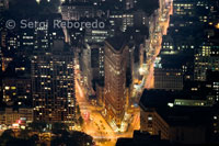 Vistas aereas del Flatiron Building. El edificio  Fuller o edificio Flatiron, como es más conocido, es un rascacielos  centenario situado en Manhattan. Era uno de los edificios más altos de Nueva York cuando finalizó su construcción en el año 1902. Recibió su nombre oficial de George A. Fuller, fundador de la empresa constructora que financió la obra y que había fallecido en el 1900. El Flatiron se encuentra en una manzana triangular, limitada al sur por la Calle 22, al oeste por la Quinta Avenida y al este por Broadway. Estas dos últimas calles confluyen delante del edificio con la Calle 23, a la altura de Madison Square. El vecindario que lo rodea recibe el nombre de distrito Flatiron en su honor. El edificio  de estilo Beaux Arts fue diseñado por el arquitecto de la escuela de Chicago Daniel Burnham. Al igual que una columna clásica griega, su fachada de caliza y terracota  está dividida horizontalmente en tres partes. El uso del acero en su construcción permitió que la obra alcanzase los 87 m de altura, lo que habría sido muy difícil empleando las técnicas habituales de la época.