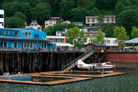 Juneau, Alaska, EE.UU.. Hidroaviones guiadas estacionados en el frente de agua en el muelle de Juneau Alaska. Downtown Juneau sienta cómodamente entre el Monte Juneau, Mount Roberts y Gastineau Channel, y es un laberinto de calles estrechas que se ejecutan más allá de una mezcla de nuevas estructuras, fachadas antiguas y pintorescas casas de arquitectura de principios del siglo 19 sobrante de días de extracción de oro a principios de la ciudad.