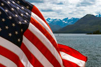 Juneau, Alaska, EUA .. Bandera americana onejant en Safari Endeavour. Estret Icy. Parc Nacional Glacier Bay ADN Preserve. Illa Chichagof. Juneau. El sud-est d'Alaska. Avui és el dia final de l'exploració. Estableixi el seu curs per possiblement les aigües de balenes més rics al sud-est d'Alaska. Mantingui el rellotge per el cop revelador de les balenes geperudes que vostè frega les aigües riques en nutrients a la recerca de balenes, dofins, lleons marins, i altres animals salvatges.