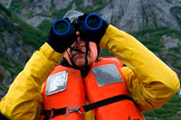 Juneau, Alaska, EE.UU.. Pasajeros con prismáticos en crucero Safari Endeavour en el ancla en Fords Terror, brazo de Endicott, Tongass National Forest, Juneau, Alaska, EE.UU.. Fiordos-Cliff paredes cortadas en la parte continental de montaña son de barril hoy como usted se desliza lentamente en un área ampliamente aclamado como el más hermoso en Alaska.