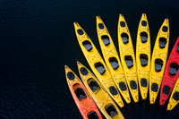 Juneau, Alaska, USA. Sea kayaks next to cruise ship Safari Endeavour near Reid Glacier in Glacier Bay National Park, Alaska, USA. All of our trips use double kayaks... for multiple reasons.  This is Alaska, and the water is very cold and the weather can be quite changeable.  Doubles are much more stable than singles, and allow us to take out paddlers of various abilities.  Plus, having two people in the boat is great if the wind picks up or someone gets tired! 