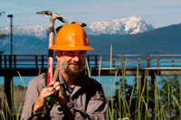 Juneau, Alaska, USA. Worker in Bartlett Cove. Pier and floating dock, Bartlett Cove, Glacier Bay National Park, Alaska. Here, just 200 years ago stood the snout of a 100-mile long glacier. Though icebergs no longer dot the waters of Bartlett Cove, the animals, plants, and landscape continue to change after being affected by the Neoglacial Ice Age. There are many ways to explore Bartlett Cove.