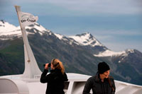 Juneau, Alaska, USA. Crew and passengers with binoculars on cruise ship Safari Endeavour at the Margerie Glacier and Mount Fairweather in Glacier Bay National Park Alaska USA. Tarr inlet in Glacier Bay National Park. Margerie Glacier is a 21-mile-long (34 km) tide water glacier in Glacier Bay in Alaska and is part of the Glacier Bay National Park and Preserve. It begins on the south slope of Mount Root, at the Alaska-Canada border in the Fairweather Range, and flows southeast and northeast to Tarr Inlet. 