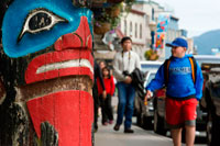 Juneau, Alaska, EE.UU.. Tótem y turistas caminando en las calles de Juneau. Alaska, EE.UU.. La ciudad y el municipio de Juneau es la capital de Alaska. Es un municipio unificado situado en el canal inglés en el panhandle de Alaska, y es la segunda ciudad más grande de Estados Unidos por área. Juneau es la capital de Alaska desde 1906, cuando el gobierno de lo que era entonces el Distrito de Alaska fue trasladado de Sitka según lo dictado por el Congreso de Estados Unidos en 1900. El municipio unificado el 1 de julio de 1970, cuando la ciudad de Juneau se fusionó con la ciudad de Douglas y los alrededores Mayor Juneau Borough para formar el municipio la autonomía actual.