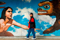 Juneau, Alaska, USA. Mural by Bill Ray "Raven Discovering Mankind in a Clam Shell" along the roadside in downtown, Juneau. Alaska. USA. Tlingit story about creation. The City and Borough of Juneau is the capital city of Alaska. It is a unified municipality located on the Gastineau Channel in the Alaskan panhandle, and is the second largest city in the United States by area. Juneau has been the capital of Alaska since 1906, when the government of what was then the District of Alaska was moved from Sitka as dictated by the U.S. Congress in 1900. The municipality unified on July 1, 1970, when the city of Juneau merged with the city of Douglas and the surrounding Greater Juneau Borough to form the current home rule municipality. 