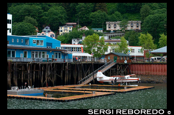 Sightseeing seaplanes parked at the water front in Juneau dock Alaska. Downtown Juneau sits snugly between Mount Juneau, Mount Roberts and Gastineau Channel, and is a maze of narrow streets running past a mix of new structures, old storefronts and quaint houses featuring early 19th century architecture left over from the town’s early gold mining days. The waterfront bustles with cruise ships, fishing boats and floatplanes zipping in and out. With no road access to Juneau, it is the only state capital in the United States that can only be reached by airplane or boat. 