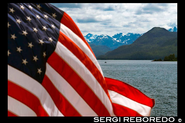 Bandera americana ondeando en Safari Endeavour. Estrecho Icy. Parque Nacional Glacier Bay adn Preserve. Isla Chichagof. Juneau. El sudeste de Alaska. Hoy es el día final de la exploración. Establezca su curso para posiblemente las aguas de ballenas más ricos en el sudeste de Alaska. Mantenga el reloj para el golpe revelador de las ballenas jorobadas que usted friega las aguas ricas en nutrientes en busca de ballenas, delfines, leones marinos, y otros animales salvajes. Únete al capitán en el puente o ir en cubierta con su Líder de Expedición. Por la tarde, la caída de las lanchas y kayaks para una inspección más cercana de la costa a distancia con los ojos fijados en la costa de posibles avistamientos de osos. Esta noche, disfrutar de la soledad mientras se relaja en la bañera de hidromasaje cubierta superior o disfrutar de una copa con sus compañeros de yachtmates en el salón.