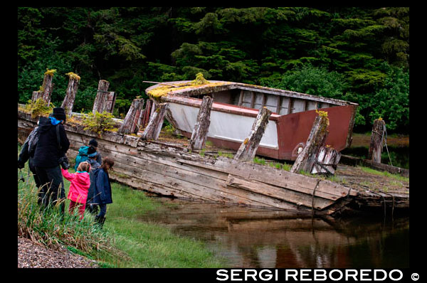 Barco viejo en un bosque templado lluvioso en las islas Brothers entre Pasaje Stephens y Frederick Sound. Archipiélago Alexander, el sudeste de Alaska. Los Tres Hermanos es un pequeño arrecife situado frente a la costa norte de la isla de Kodiak, Alaska, a unos 2 km al este de Shakmanof Point y 2,5 km al oeste de Ouzinkie. El arrecife se extiende sobre 550 m en el suroeste de dirección noreste, y algunas partes de ella a descubrir unos 60 cm. Dos rocas en el extremo suroeste descubren en alrededor de 1,2 m, y una roca en el extremo noreste destapa por alrededor de 1 m. Hay una luz en la roca southwesternmost. Un bosque de algas se extiende unos 250 yardas outh de la luz hacia la Isla Baja.