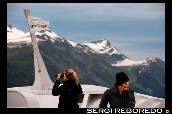 Tripulación y pasajeros con prismáticos en crucero Safari Endeavour en el glaciar de Margerie y el Monte Fairweather en Glacier Bay Parque Nacional de Alaska EE.UU.. Tarr entrada en el Parque Nacional Glacier Bay. Margerie glaciar es una 21 millas de largo (34 km) marea glaciar agua en Glacier Bay en Alaska y es parte del Parque Nacional y Reserva Glacier Bay. Se inicia en la ladera sur del monte Root, en la frontera de Alaska-Canadá en la Cordillera Fairweather, y fluye sureste y noreste de Tarr Inlet. Fue nombrado para el famoso geógrafo y geólogo francés Emmanuel de Margerie (1862-1953), quien visitó el Glacier Bay en 1913. Es una parte integral de la Bahía de los Glaciares, declarado Monumento Nacional el 26 de febrero de 1925, un Parque Nacional y Vida Salvaje Preservar el 2 de diciembre de 1980, la UNESCO declaró una Reserva Mundial de la Biosfera en 1986 y Patrimonio de la Humanidad en 1992. Mientras que la mayoría de la marea y los glaciares terrestres en el Parque se declaró ser el adelgazamiento y el retroceso en los últimos décadas, Margerie glaciar se dice que es estable y el glaciar de Johns Hopkins se dice que es el avance, en la cara oriental de la Cordillera Fairweather.