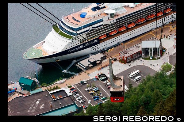 Juneau downtown, city. Alaska. USA. Celebrity Millennium cruise ship docked between snow capped mountains and the Mount Roberts Tramway in Juneau dock, Alaska, USA. Cruise Ship Terminal and Mt Roberts Tramway, Alaska, Inside Passage, United States of America. The Mount Roberts Tramway is an aerial tramway located just south of downtown Juneau in the U.S. state of Alaska. In operation since 1996, the tram makes a six-minute ascent of 3,819-foot (1,164 m) Mount Roberts from the cruise ship docks (just feet above sea level) to a height of about 1,800 feet (550 m). A restaurant, theater, nature center and retail shops are located at the top of the tramway, as well as connections to trails leading both up and down the mountain. One trail up the mountain leads to a large cross[1] erected by Roman Catholic Father Brown in the early 1900s.