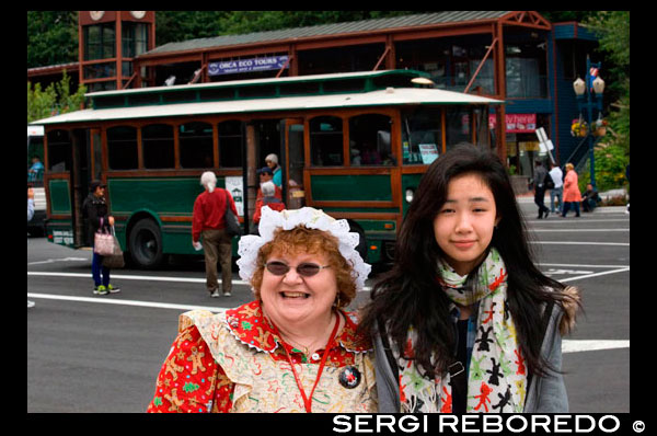 Vestidos como indios para tomar la fotografía. Juneau, Alaska. EE.UU.. Carro antiguo. Las personas que reciben en el trolebús cerca de Mt Roberts Tranvía en centro de la ciudad de Juneau, Alaska, Estados Unidos. Ciudad y Glaciar Información | $ 35.00 | 2,5 horas | Por autocar. Disfrute de un recorrido narrado ciudad con uno de nuestros guías locales capacitados. Los nativos de Juneau, conductores Archie Lee y Ben Jackson, indios Tlingit, le regale con historias de la historia local que se remonta 10.000 años - hasta el comienzo de la historia humana en la zona. Usted escuchará acerca de los orígenes de la tribu Haida-Tlingit, el impacto de influencias rusas, europeas y americanas, y el oro que se formó el pasado y por lo tanto el presente. Usted pasará por encima del Canal Gastineau para ver el increíble panorama de Juneau.