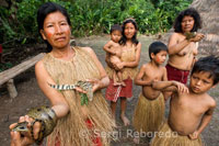 Yagua town. A woman sits riverside with his daughter.