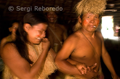 Poblat yagua. Interior d'una cabana per assistir a una mena de ball cerimonial anomenat bujurqui, en el qual dansen amb foc en cercle. Al moment del contacte europeu, segons Chaumeil, els Yaguas mantenien relacions asimètriques amb els Omagua (Tupí) dels que eren servidors domèstics i esclaus. A l'arribada dels jesuïtes, les missions es converteixen en zones de refugi per als indígenes perseguits pels "bandeirantes" esclavistes. Inicialment hostils a les missions, majoritàriament poblades per omahuas, davant l'amenaça dels "bandeirantes", els Yaguas finalment van buscar la protecció dels missioners. No obstant això, les epidèmies que periòdicament es deslligaven en les reduccions van portar a mútues acusacions de bruixeria entre els grups que hi habitaven produint guerres.
