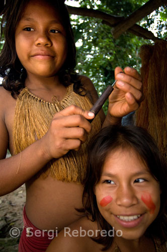 Yagua town. A painted girls pose for the camera. To reach the town of Yaguas you have to go by boat from Iquitos touring the Amazon River for an hour and a half. Then you need to enter the river Yanayacu calm waters. This tribe very hospitable offers a kind of show to all tourists who visit which is a typical dance of them, and the demonstration of the shot with the "blow-gun." You can talk to them, although not all speak Spanish.