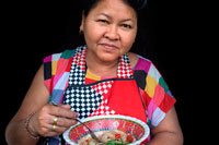 Bangkok. Una mujer comiendo una típica ensalada de papaya verde en las calles de Bangkok. Esta ensalada de papaya verde, también conocido como "som tam", es popular en todo el mundo, y cuando te gusto él se puede saber por qué. El sabor ligeramente ácido de la papaya verde combina maravillosamente con la especia de chile rojo y la salinidad de salsa de pescado y la dulzura de la miel (tenga en cuenta que también puede hacerse vegetariana / vegana - ver receta). Ensalada de papaya verde es un plato muy bien único y lleno de sabor que hará una gran impresión. También es fácil de hacer, baja en calorías y muy nutritivo.