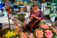 Bangkok. Dona venedora de flors de lotus en Pak Khlong Talat, Mercat de les flors, Bangkok, Tailàndia. Pak Khlong Talat és un mercat a Bangkok, Tailàndia, que ven flors, fruites i verdures. És el mercat de flors primària a Bangkok i ha estat citat com un "lloc de [] de valors simbòlics" als residents de Bangkok. Està situat a Chak Phet Road i carrerons adjacents, a prop de Memorial Bridge. Encara que el mercat està obert les 24 hores, és més actiu abans de l'alba, quan els vaixells i els camions arriben amb les flors de les províncies properes.