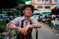 Bangkok. Pak Khlong Talat és un mercat a Bangkok coneguda per les seves flors a l'engròs. No obstant això, poc s'ha escrit sobre els volums de fruites i verdures fresques en el qual Pak Khlong Talat va ser un cop establerta durant el seu regnat com el major mercat de productes a granel de Bangkok. Durant una visita primerenca matí de diumenge, explorem una de les més impressionants mostres de productes frescos en els quals m'he trobat. El Pak Khlong Talat és un mercat de productes a l'engròs, és evident per les seves exhibicions massives de fruites i verdures. No es teixeixen cistells la mida de barrils de vi que són la llar de gingebre ratllat, els xilis, i les taronges; manats d'herba de llimona i espàrrecs amb prou feines capaç d'encaixar sota el braç; camions de cols, cebes i all.