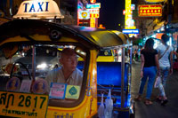 Bangkok. Tuk tuk al carrer. Vegi baix de la carretera Thanon Yaowarat a la nit al cèntric barri de Chinatown de Bangkok, Tailàndia. Yaowarat i Phahurat és multicultural barri de Bangkok, situada a l'oest de Silom i sud-est de Rattanakosin. Yaowarat Road és la llar de la comunitat xinesa gran de Bangkok, mentre que els d'ètnia índia s'han congregat al voltant Phahurat Road. Durant el dia, Yaowarat no es veu molt diferent de qualsevol altra part de Bangkok, encara que el barri se sent com un gran mercat del carrer i hi ha algunes joies ocultes esperant a ser explorat. Però a la nit, els rètols de neó resplendents amb caràcters xinesos estan encesos i les multituds dels restaurants es deixen caure pels carrers, convertint la zona en una miniatura de Hong Kong (menys els gratacels).