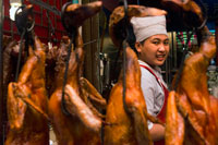 Bangkok. Cocina y asado atardecer en un repetíamos. Mercado de Bangkok Chinatown, Tailandia. Carretera Thanon Yaowarat en la noche en el céntrico barrio de Chinatown de Bangkok, Tailandia. Yaowarat y Phahurat es multicultural barrio de Bangkok, situada al oeste de Silom y sureste de Rattanakosin. Yaowarat Road es el hogar de la comunidad china grande de Bangkok, mientras que los de etnia india se han congregado alrededor Phahurat Road. Durante el día, Yaowarat no se ve muy diferente de cualquier otra parte de Bangkok, aunque el barrio se siente como un gran mercado de la calle y hay algunas joyas ocultas esperando a ser explorado. Pero por la noche, los letreros de neón resplandecientes con caracteres chinos están encendidos y las multitudes de los restaurantes se dejan caer por las calles, convirtiendo la zona en una miniatura de Hong Kong (menos los rascacielos).