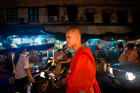 Bangkok. Monje en la noche en Pak Khlong Talat, Mercado de las flores, Bangkok, Tailandia. Pak Khlong Talat es un mercado en Bangkok, Tailandia, que vende flores, frutas y verduras. Es el mercado de flores primaria en Bangkok y ha sido citado como un "lugar de [] de valores simbólicos" a los residentes de Bangkok. Está situado en Chak Phet Road y callejuelas adyacentes, cerca de Memorial Bridge. Aunque el mercado está abierto las 24 horas, es más activo antes del amanecer, cuando los barcos y los camiones llegan con las flores de las provincias cercanas. El mercado tiene una larga historia. Durante el reinado de Rama I (1782-1809), un mercado flotante tuvo lugar en el sitio de la moderna Pak Khlong Talat; por el reinado de Rama V (1868-1910), que había cambiado a un mercado de pescado. El mercado de pescado se convirtió posteriormente al mercado de productos de hoy, que ha existido durante más de 60 años.